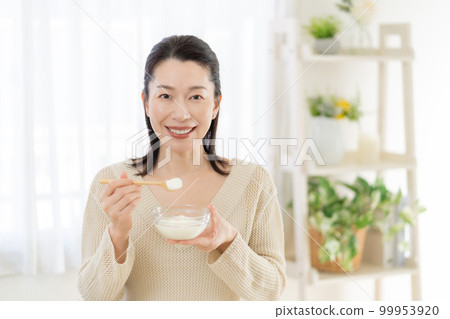 Intestinal activity Middle-aged woman eating yogurt Intestinal activity Middle-aged woman eating yogurt 99953920