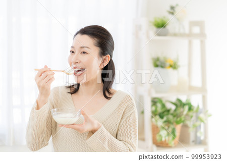 Intestinal activity Middle-aged woman eating yogurt 99953923