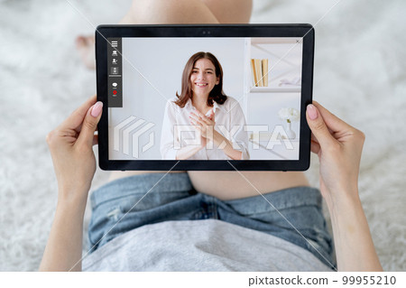 Video call. Home e-learning. Digital education. Relaxed female student watching online lesson with satisfied teacher applauding on tablet screen. 99955210