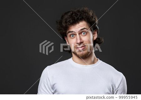 young bearded man in casual white t-shirt looking at the camera 99955945