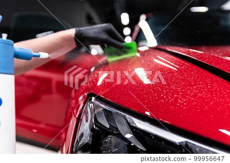 Application of a colorless protective film at a car detailing studio or car wash.  99956647