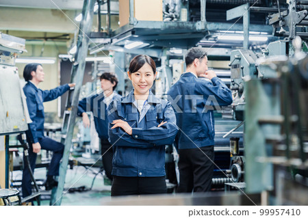 Female worker working in a factory with a smile Female worker working in a factory with a smile 99957410