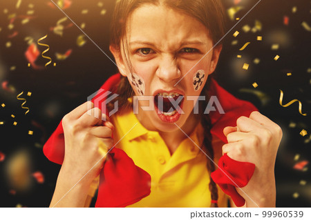Young girl emotionally watching football match, cheering up favorite team over dark background with confetti 99960539