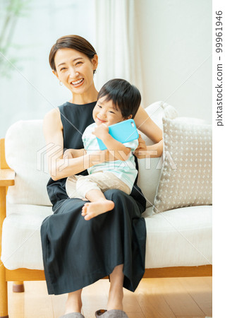 A 2-year-old boy and a mother watching a video on a smartphone 99961946