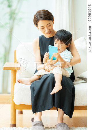 一個 2 歲男孩和一位母親在智能手機上觀看視頻 99961948