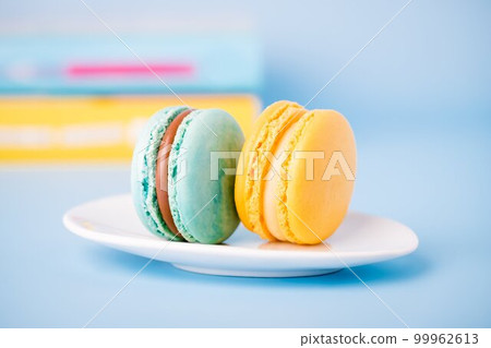 Mint color and yellow macaron on a blue background, copy space Mint color and yellow macaron on a blue background, copy space 99962613