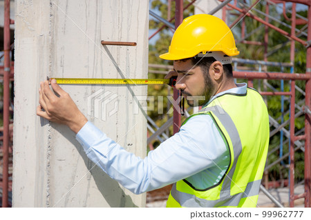 Engineer young man using tape measure for check and examining length of structure. 99962777