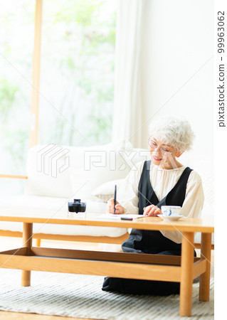 Senior woman writing a letter with a fountain pen 99963062