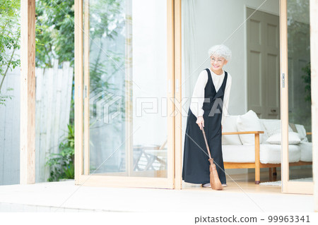 用棕櫚掃帚清潔的高級婦女 99963341