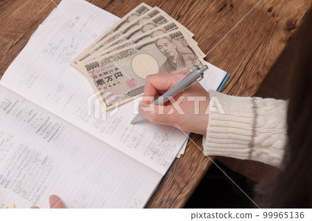 [A housewife with a household account book and a 10,000 yen bill] 99965136
