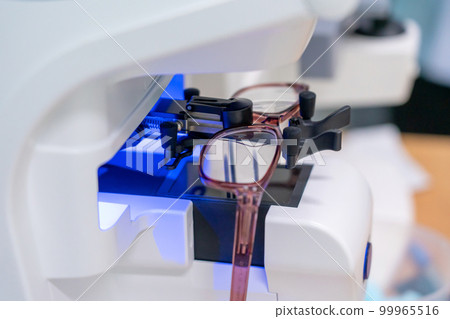 preparing glasses on the latest digital device in optical store. Professional ophthalmology instrument in clinic office and optics 99965516