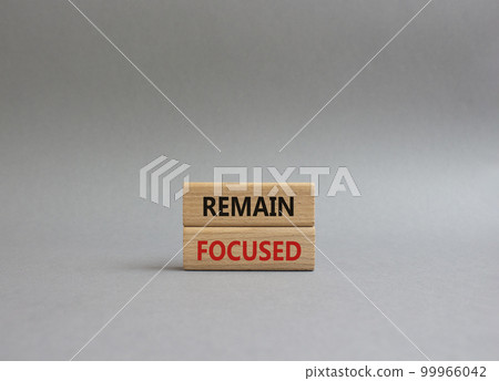 Remain focused symbol. Concept words Remain focused on wooden blocks. Beautiful grey background. Business and Remain focused concept. Copy space. Remain focused symbol. Concept words Remain focused on wooden blocks. Beautiful grey background. Business and Remain focused concept. Copy space. 99966042