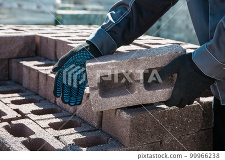 Closeup of hand of a worker in a protective glove with brick. Closeup of hand of a worker in a protective glove with brick. 99966238