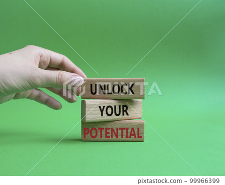 Unlock your Potential symbol. Wooden blocks with words Unlock your Potential. Beautiful green background. Businessman hand. Business and Unlock your Potential concept. Copy space. 99966399