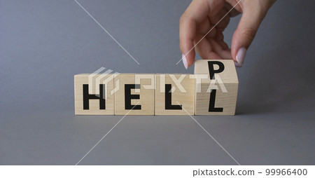 Help vs Hell symbol. Businessman hand Turnes cube and changes word Hell to Help. Beautiful grey background. Psychology and Help vs Hell concept. Copy space 99966400