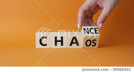 Chance vs Chaos symbol. Businessman hand Turnes cube and changes word Chaos to Chance. Beautiful orange background. Psychology and Chance vs Chaos concept. Copy space 99966402