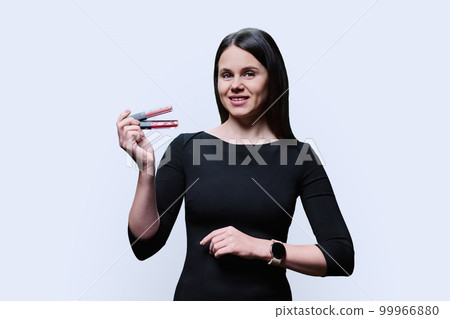 Young woman showing trendy red and nude lip glosses, on white background 99966880