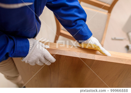 Woman in work clothes Unloading furniture Woman in work clothes Unloading furniture 99966888