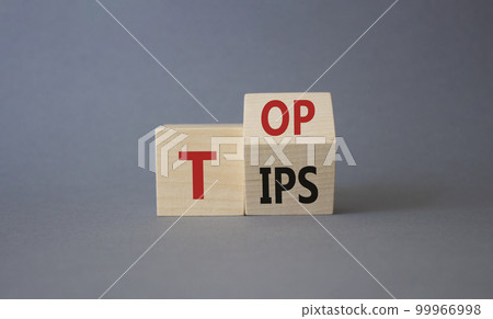 Top Tips symbol. Turned wooden cubes with words Top Tips. Beautiful grey background. Business and Top Tips concept. Copy space 99966998