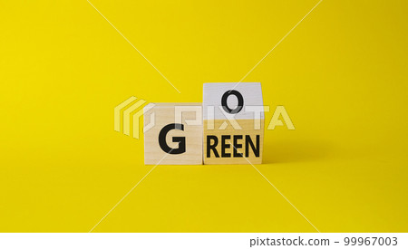 Go green symbol. Turned wooden cubes with words Go Green. Beautiful yellow background. Ecological and Business and Go green concept. Copy space Go green symbol. Turned wooden cubes with words Go Green. Beautiful yellow background. Ecological and Business and Go green concept. Copy space 99967003