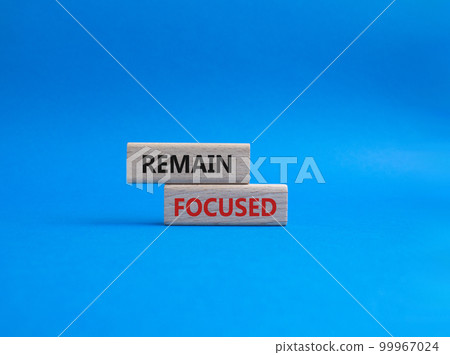 Remain focused symbol. Concept words Remain focused on wooden blocks. Beautiful blue background. Business and Remain focused concept. Copy space. Remain focused symbol. Concept words Remain focused on wooden blocks. Beautiful blue background. Business and Remain focused concept. Copy space. 99967024