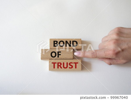 Bond of trust symbol. Wooden blocks with words Bond of trust. Beautiful white background. Businessman hand. Business and Bond of trust concept. Copy space. Bond of trust symbol. Wooden blocks with words Bond of trust. Beautiful white background. Businessman hand. Business and Bond of trust concept. Copy space. 99967040