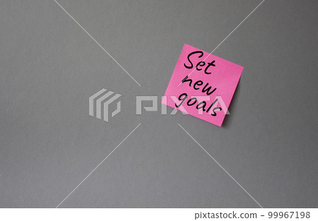 Set New Goals symbol. Concept words Set New Goals on pink steaky note. Beautiful grey background. Business and Set New Goals concept. Copy space. 99967198