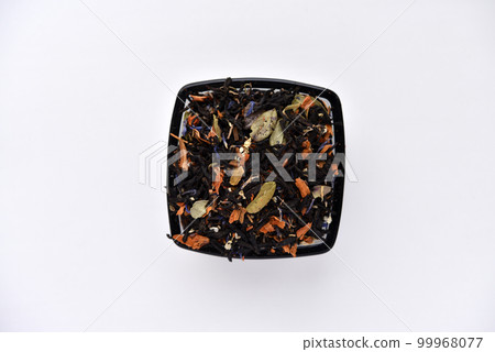 Black tea with spices in a glass cup on a white background. Delicious tea. Dry tea. Black tea with spices in a glass cup on a white background. Delicious tea. Dry tea. 99968077