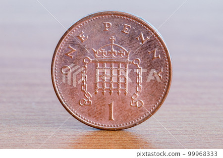 UK one penny coin on wooden table. UK one penny coin on wooden table. 99968333