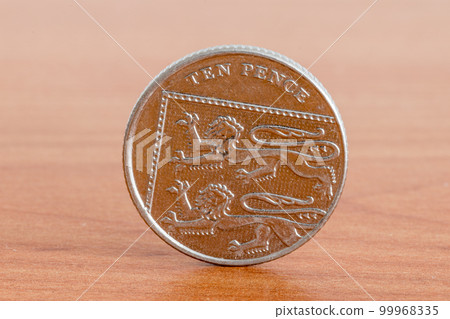 UK ten pence coin on wooden table. UK ten pence coin on wooden table. 99968335
