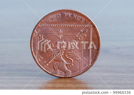 UK two pence coin on wooden table. UK two pence coin on wooden table. 99968336