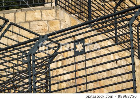 Metal black railings on stone walls 99968756
