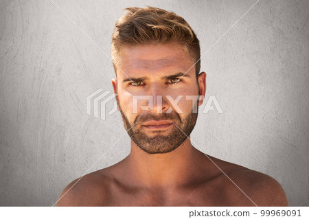 Close up portrait of good-looking male with dark eyes, bristle and trendy hairdo being naked, looking with serious expression at camera, isolated over grey background. Topless young macho man Close up portrait of good-looking male with dark eyes, bristle and trendy hairdo being naked, looking with serious expression at camera, isolated over grey background. Topless young macho man 99969091