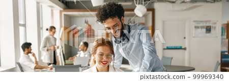 Businesspeople working together in bright office, sitting at desk Businesspeople working together in bright office, sitting at desk 99969340
