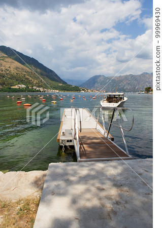 Very beautiful promenade of the Bay of Kotor, a small fishing boat. Montenegro. Beautiful and cozy city, Kotor embankment. The concept of rest and vacation in Europe. 99969430