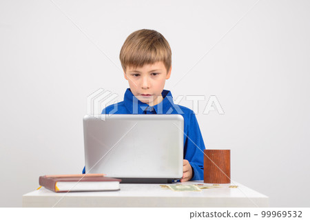young businessman Young smart boy looking netbook next to the ta young businessman Young smart boy looking netbook next to the ta 99969532