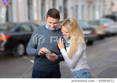 girl blond and guy looking something in the mobile phone and smi girl blond and guy looking something in the mobile phone and smi 99969612