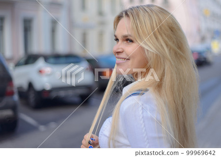 smiling stylish blond girl on city street smiling stylish blond girl on city street 99969642