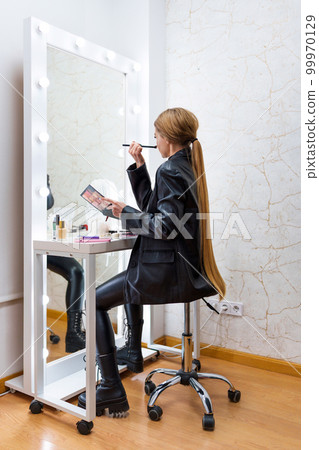 Rear view of a woman making up on a backstage Rear view of a woman making up on a backstage 99970129