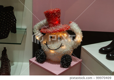 toy in the form of a ball in a hat on the shop window among the shoes 99970409