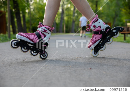 A woman rollerblading on an asphalt alley. A woman rollerblading on an asphalt alley. 99971236