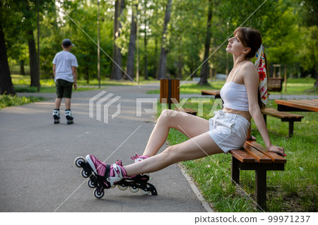Girls and on roller skates relaxes after a practice. Girls and on roller skates relaxes after a practice. 99971237
