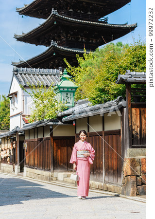 一位身著和服的年輕女子站在五層寶塔的背景下 99972232