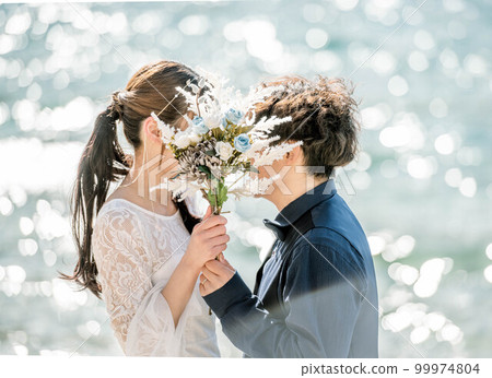 新娘和新郎拿著花束，看著對方 99974804
