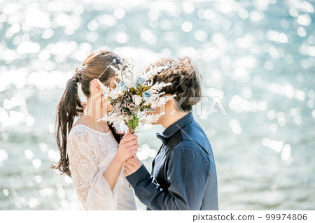 新娘和新郎拿著花束,看著對方 新娘和新郎拿著花束,看著對方 99974806