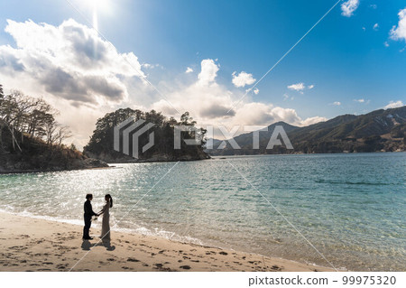 Bride and groom looking at each other on the beach Bride and groom looking at each other on the beach 99975320