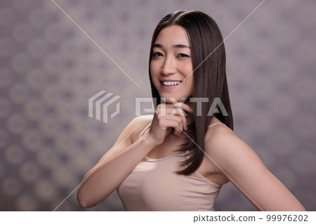 Asian young woman rubbing chin for face portrait. Attractive confident smiling lady doing thinking gesture with optimistic facial expression, posing and looking at camera 99976202