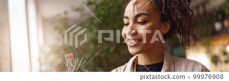 Woman florist takes care of seedlings in floral studio. Gardening concept. Blurred background 99976908