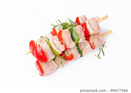 Raw turkey skewers with vegetables, peppers, onions on a white background.Skewers with pieces of raw meat, red, and green pepper, on white background.Top view.Uncooked mixed meat skewer with peppers. 99977366