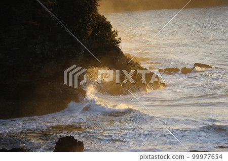 Morning seascape with rough stormy waves hitting rocks and splashing Morning seascape with rough stormy waves hitting rocks and splashing 99977654
